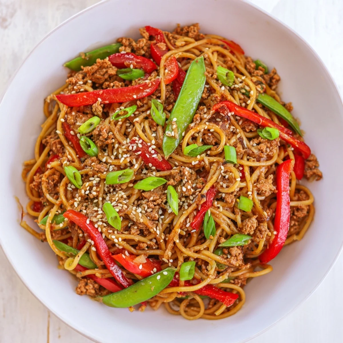 Close-up of freshly made Sesame Hoisin Ground Chicken Pasta, garnished with sesame seeds and green onions.