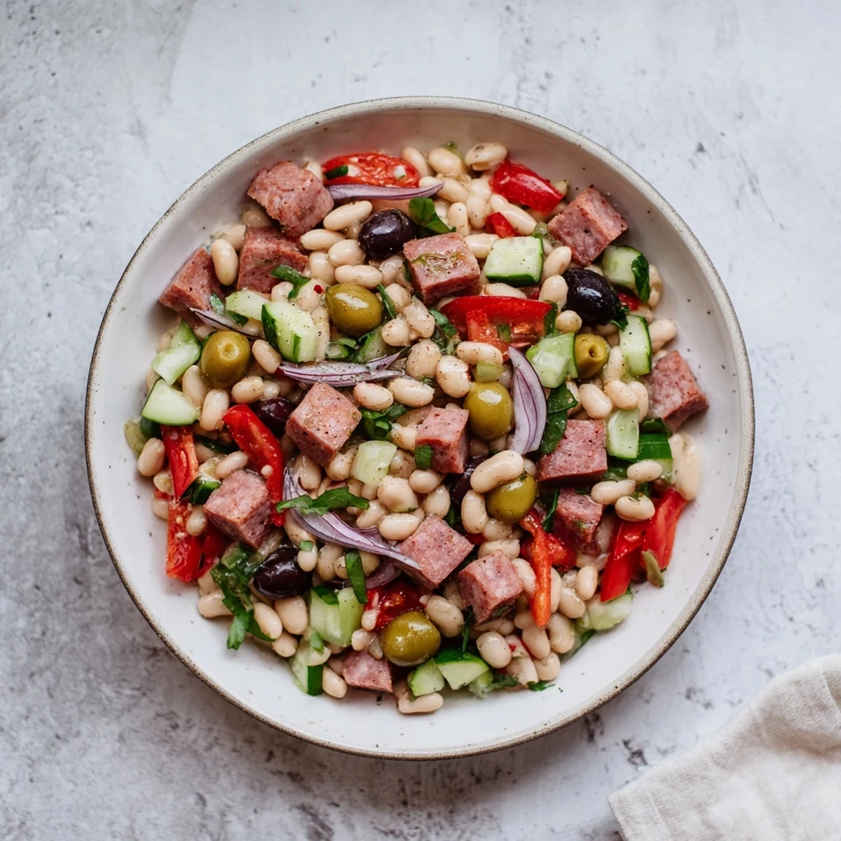 This Mediterranean Dense Bean Salad with salami features hearty beans and fresh veggies tossed in a zesty dressing.