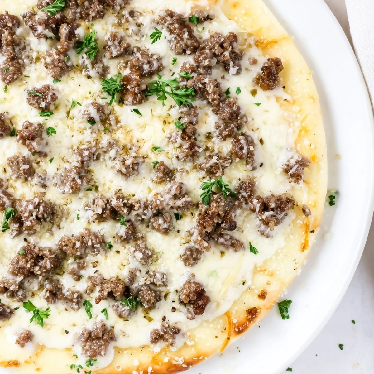 Ground Beef Alfredo Pizza boasts melted mozzarella atop a richly sauced, savory ground beef base.