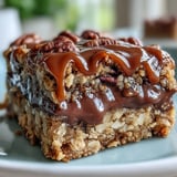 Close-up of Decadent Sweet and Chewy Turtle Bars with Chocolate and Caramel showing melted chocolate and gooey caramel between oats.