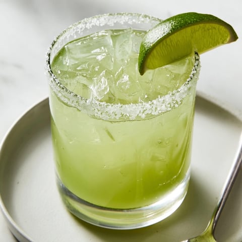 Salty rimmed classic margarita ready to sip; a tart, refreshing cocktail.