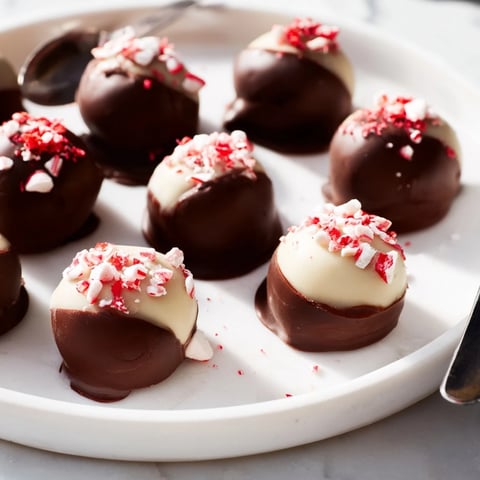 Bite-sized Charcuterie Board Peppermint Bark Balls drizzled with white chocolate and crushed candies.  