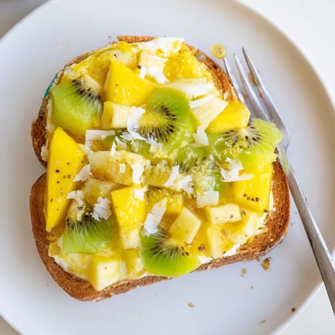 Creamy yogurt-custard toast topped with tropical fruits for a vibrant brunch.  