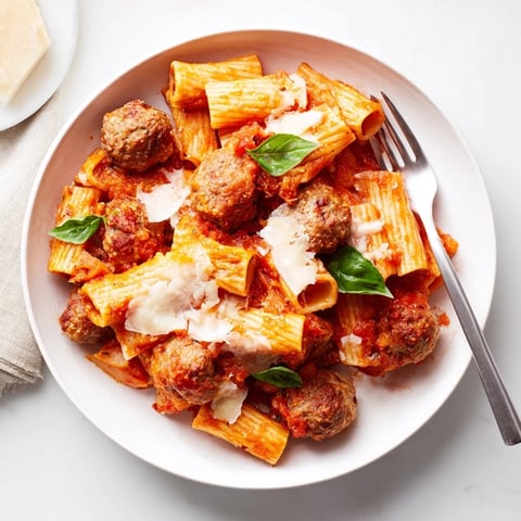Hearty Italian Meatball Pasta Skillet topped with melted cheese and fresh basil.  
