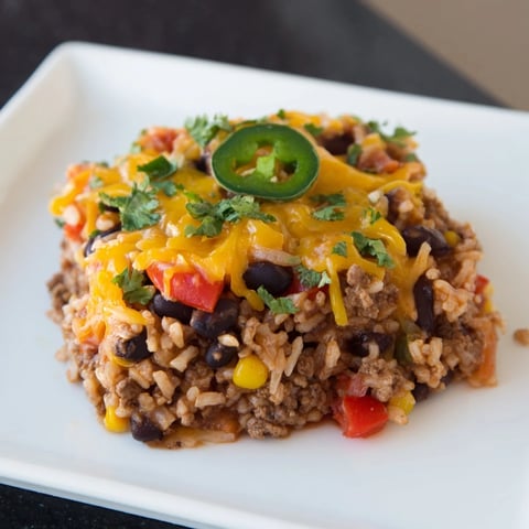 Steaming Tex-Mex Beef & Rice Casserole, topped with melted cheese, offers a comforting, savory meal.