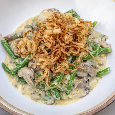 Golden-brown Old-School Green Bean Casserole with crispy onions, bubbling in a baking dish, ready to eat.