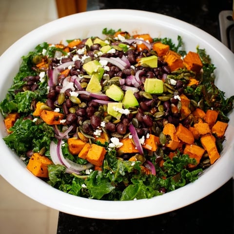 Massaged Kale Salad with Black Beans & Sweet Potato, a colorful vegetarian dish with lime dressing.