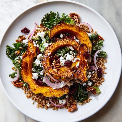 A colorful bowl of Farro & Mustard Green Salad with maple-roasted squash, ready to serve and enjoy.
