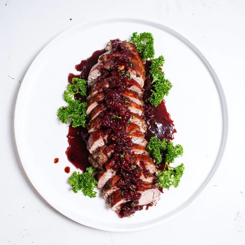 Tender, glazed Tart Cherry Date Pork Tenderloin, glistening from the oven, served with a rich, dark sauce.