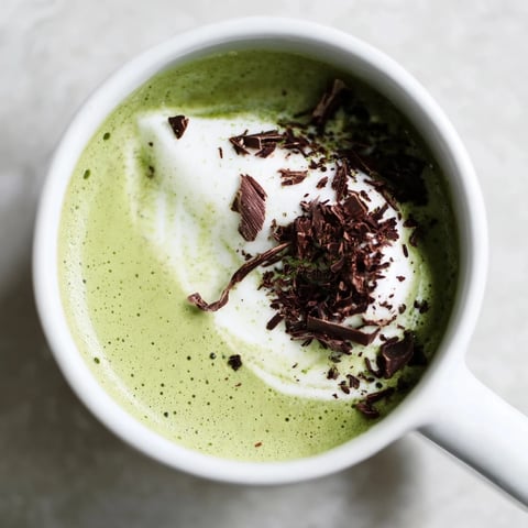 Steaming Collagen Peppermint Mocha Matcha Latte, a vibrant green and cocoa-brown beverage, ready to be enjoyed.