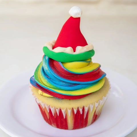 Close-up of an Elf Hat Cupcake Tower, showing vibrant buttercream swirls and decorative fondant hats.