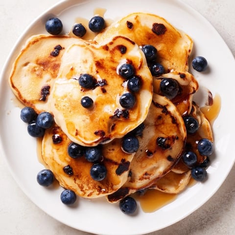 Fluffy scrambled pancakes, golden brown and gently folded, delicious breakfast served with fresh blueberries.