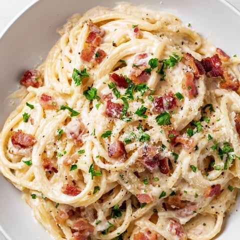 A creamy bowl of Creamy Garlic Bacon Pasta with crispy bacon and fresh parsley.