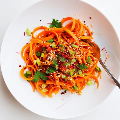 Thin ribbons of carrots tossed in a zesty soy-sesame dressing with toasted sesame seeds, garnished with fresh cilantro.  