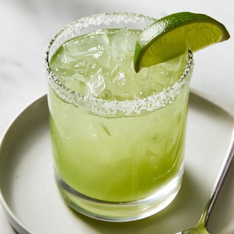 Salty rimmed classic margarita ready to sip; a tart, refreshing cocktail.