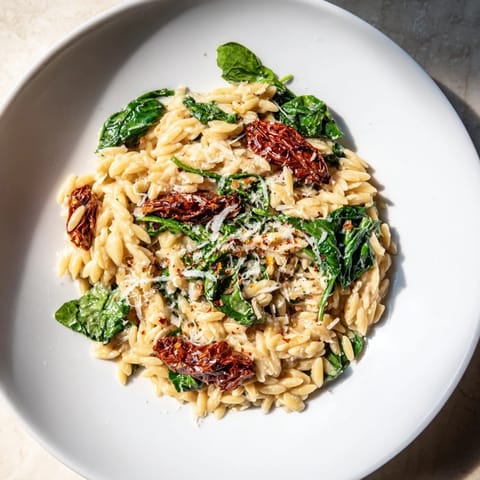 A steaming bowl of creamy Tuscan Orzo, a blend of flavors and textures in every comforting bite.