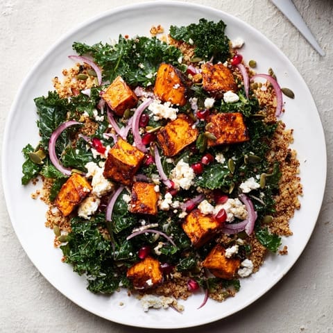 A colorful bowl of Kale & Quinoa Salad, featuring roasted sweet potatoes and a bright lemon dressing.
