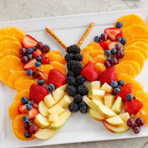 Freshly assembled Monarch Magic Fruit Butterfly Tray featuring oranges, grapes, and berries; a delightful appetizer.