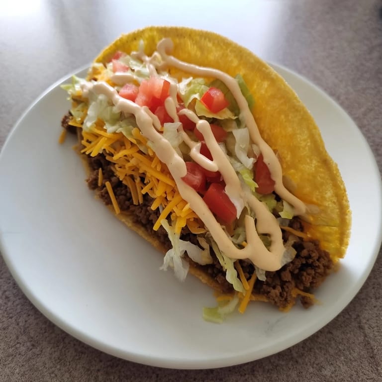 Homemade Cheesy Gordita Crunch Tacos: a close-up photo shows the cheesy shell overflowing with beef and fresh toppings.