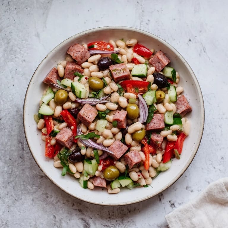 This Mediterranean Dense Bean Salad with salami features hearty beans and fresh veggies tossed in a zesty dressing.
