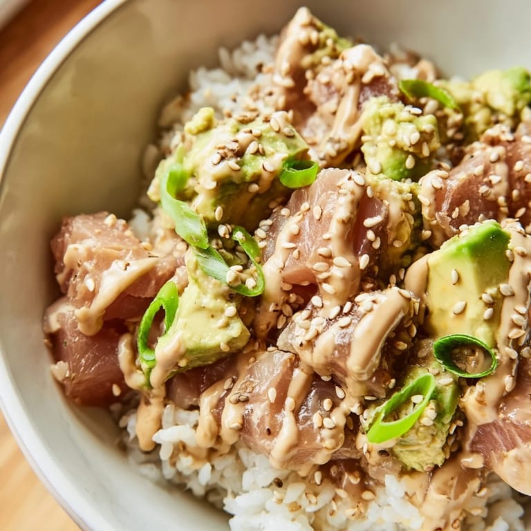 Serve this Tuna Avocado Rice Bowl topped with toasted sesame seeds and nori strips for an easy, nutritious weeknight meal.