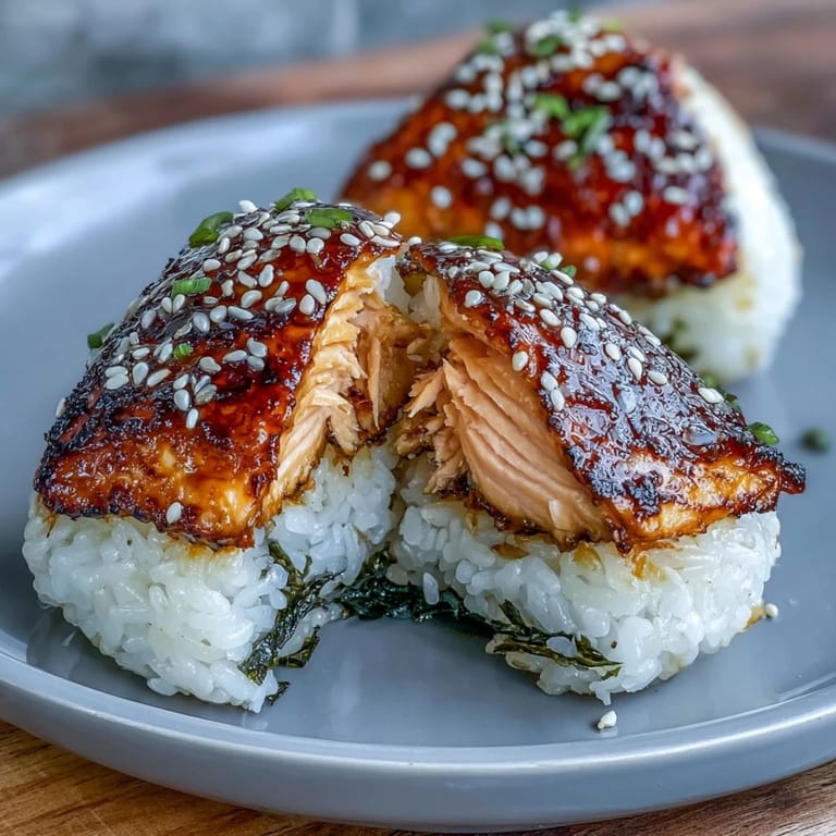 Warm Japanese rice balls packed with flaky grilled salmon, lightly charred for a satisfying, umami-rich snack.