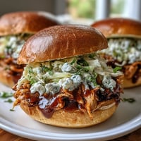 1. Juicy pulled BBQ chicken sandwiches piled high on soft brioche buns, topped with creamy coleslaw for the ultimate summer meal.  